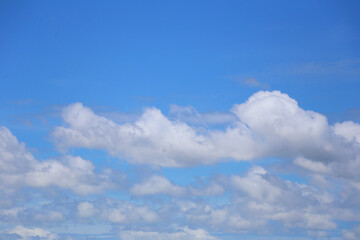 Blue sky with white clouds in the daytime background.