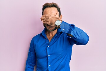 Middle age man wearing casual clothes smiling and laughing with hand on face covering eyes for surprise. blind concept.