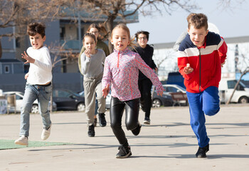 Obraz premium Group of joyful children running down the city street. High quality photo