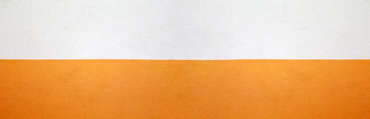 Wide cement wall painted orange and cream color background.