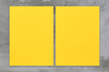Yellow paper placed on a cement wall background.