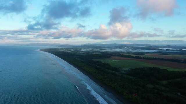 sunrise over langostino beach tropical jungle and farm fields Costa Rica 