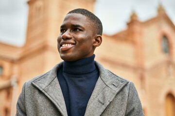 Young african american man smiling happy standing at the city