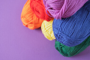 skeins of lgbt flag colors on purple background copy space