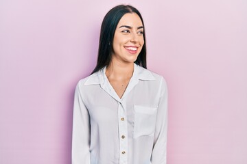 Beautiful woman with blue eyes wearing casual white shirt looking away to side with smile on face, natural expression. laughing confident.