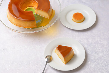 PUDDING ON A TRANSPARENT PLATE AND A SLICE OF PUDDING ON A WHITE PLATE 