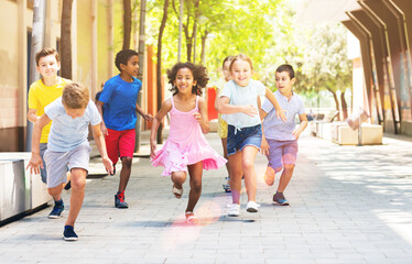 Happy children running in race and laughing outdoors at sunny day