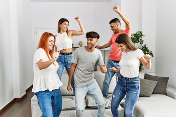 Fototapeta premium Group of young friends smiling happy and dancing at home.