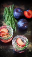 Detox water with plums and thyme. Healthy summer drinks. Refreshing drink with mineral water. The keto diet.