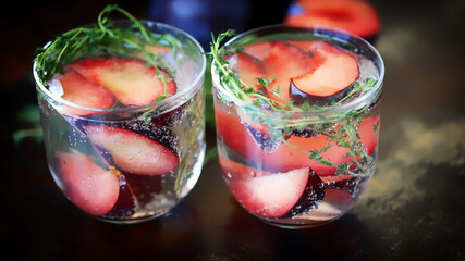 Detox water with plums and thyme. Healthy summer drinks. Refreshing drink with mineral water. The keto diet.