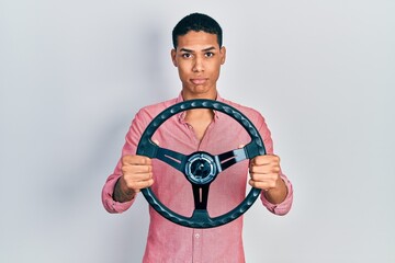 Young african american guy holding steering wheel depressed and worry for distress, crying angry and afraid. sad expression.