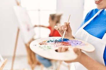 Two artist student women smiling happy painting at art school.