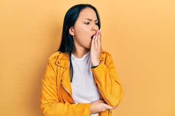 Beautiful hispanic woman with nose piercing wearing yellow leather jacket bored yawning tired covering mouth with hand. restless and sleepiness.