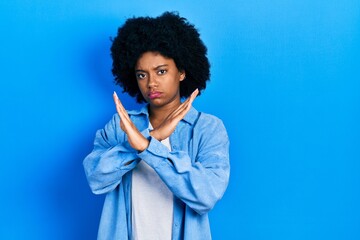 Fototapeta na wymiar Young african american woman wearing casual clothes rejection expression crossing arms doing negative sign, angry face