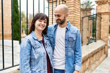 Young hispanic couple smiling happy standing at the city.