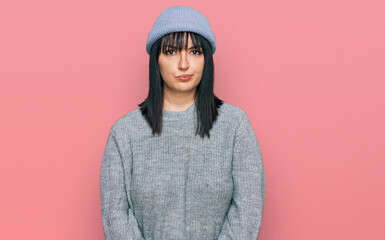 Young hispanic woman wearing cute wool cap skeptic and nervous, frowning upset because of problem. negative person.
