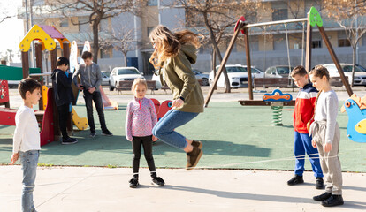 Positive children skipping on chinese jump rope on playground