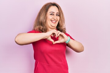 Middle age caucasian woman wearing casual clothes smiling in love doing heart symbol shape with hands. romantic concept.