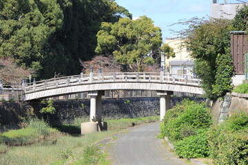 幅の狭い川に、やや反った木造橋が架けられている風景