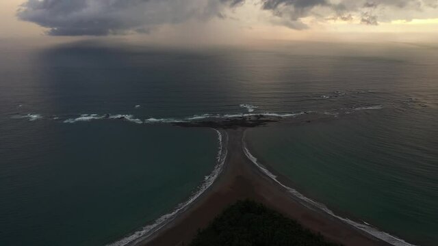 Amazing rainy sunset stormy clouds over Uvita&rsquo;s whale Tail rock sand formation Marino Ballena National Park aerial