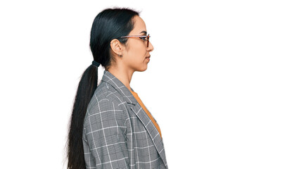 Young hispanic girl wearing business jacket and glasses looking to side, relax profile pose with natural face with confident smile.