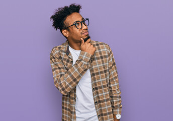 Young african american man with beard wearing casual clothes and glasses thinking worried about a question, concerned and nervous with hand on chin