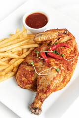 spicy portuguese piri piri half chicken with fries on plate