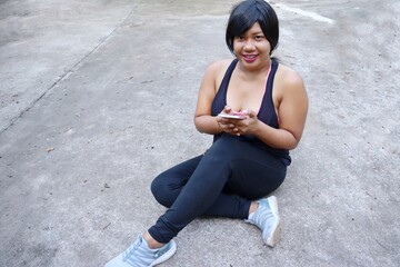 Portrait of Asia woman happy smile fitness sport and using smart phone on hand