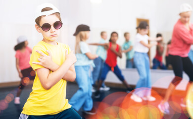Fototapeta premium Portrait of boy hip hop dancer exercising with friends at dance class