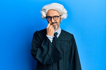 Middle age hispanic man wearing judge uniform thinking concentrated about doubt with finger on chin...
