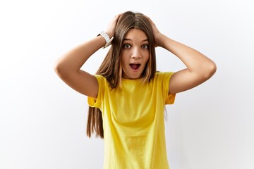 Young brunette teenager standing together over isolated background crazy and scared with hands on head, afraid and surprised of shock with open mouth