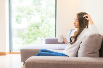 Portrait beautiful young asian woman with coffee cup on sofa