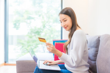 Portrait beautiful young asian woman use laptop credit card for online shopping