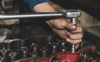 The mechanic is checking the engine.