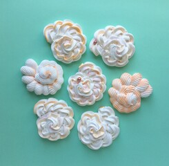 Seven meringue seashells on a green background