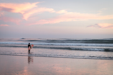 Fototapeta na wymiar solo surfer takes in the beauty of the oregon coast