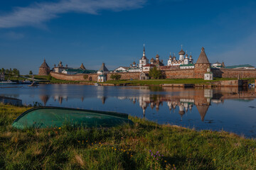 View of the Spaso-Preobrazhensky Solovetsky Monastery on the shore of the White Sea Bay and the old boat in the foreground on a cloudless summer day, Solovetsky Island, Arkhangelsk region, Russia