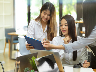 Business worker showing the data report to her colleague at office room
