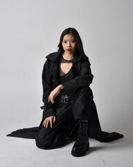 Full length portrait of pretty young asian girl wearing black tank top, utilitarian  pants, leather...