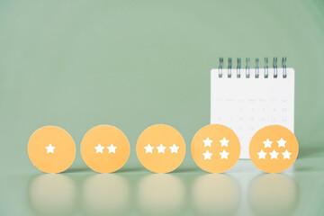 rating stars on yellow circle paper with blurred white calendar, ranking, survey, feedback,...