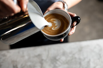 Baretta is making hot coffee in the shape of a heart in the morning.