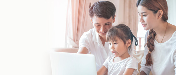 Happy Asian family using laptop in living room