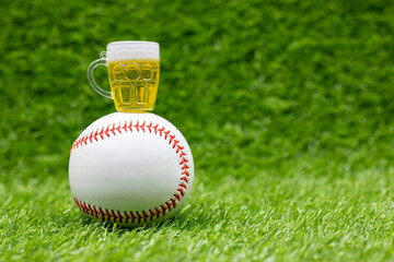 Baseball with glass of beer ar on green grass