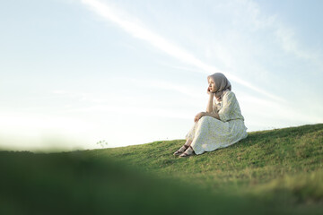 Woman with white dress enjoying the sunset on the grass. Summer vacation at Buffalo Village