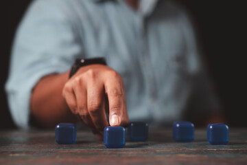 A businessman's hand points to an empty blue square block. The concept of pointing out a clear goal.