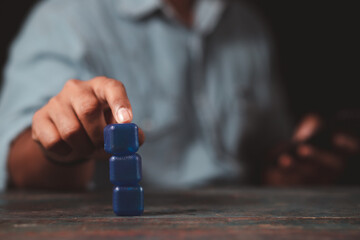 A businessman's hand points to an empty blue square block. The concept of pointing out a clear goal.