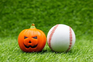 Baseball halloween with pumpkin on green grass