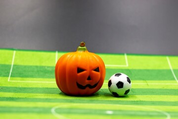 Halloween with soccer ball is on green grass on Halloween day