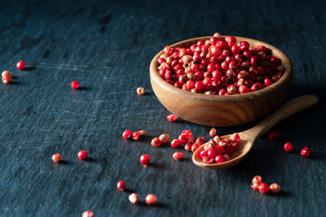 red peppers grain or peppercorns in the vintage brown wooden bowl