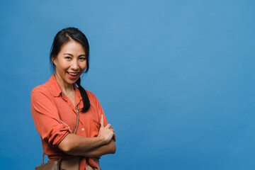 Portrait of young Asia lady with positive expression, arms crossed, smile broadly, dressed in casual clothing and looking at camera over blue background. Happy adorable glad woman rejoices success.